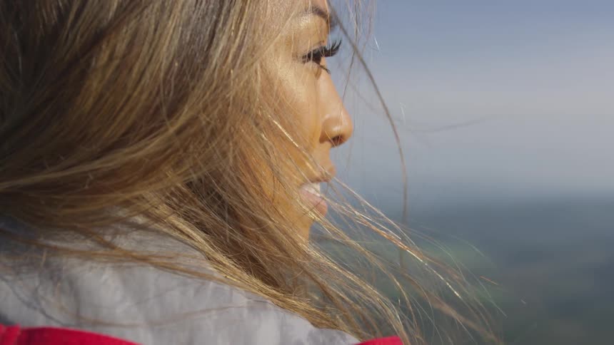A woman is smiling outdoors