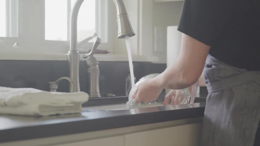 A person is washing dishes in a sink