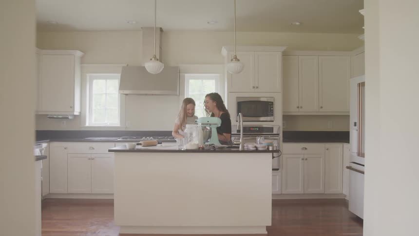 A mother bakes at home with her young daughter