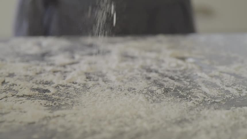 A person rubbing flour on their hands to cook