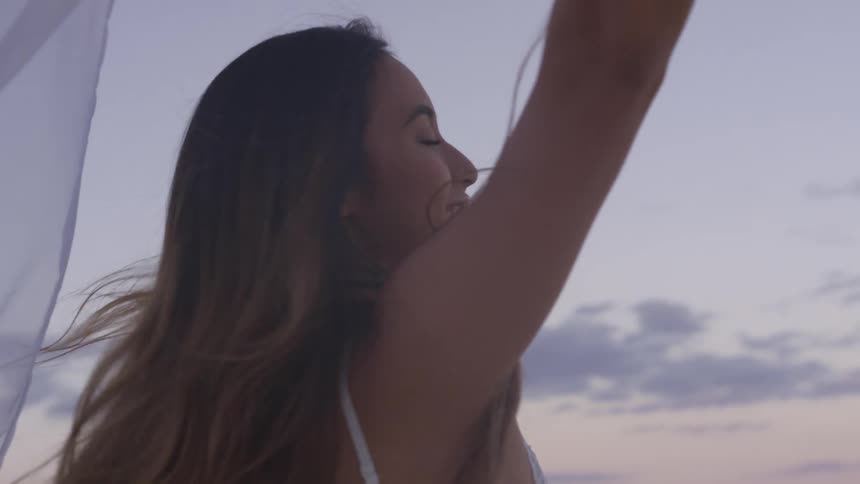 A woman is dancing at the beach