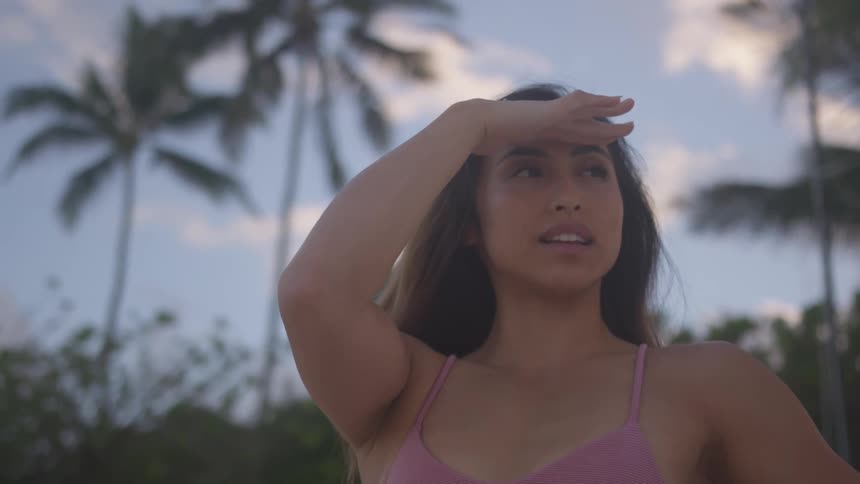 Young woman in a swimsuit in a tropical island looking at the horizon