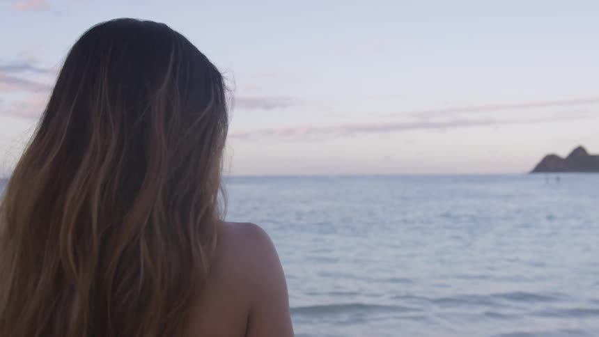 A woman is standing at a beach in spring