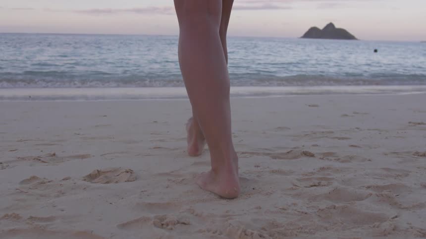 A woman is walking on the beach