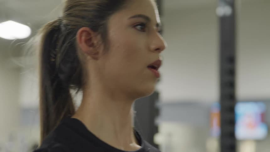 A teenage girl doing bicep curls
