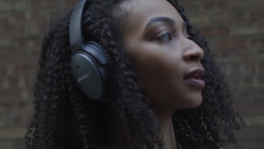 A young black woman listens to music and dances