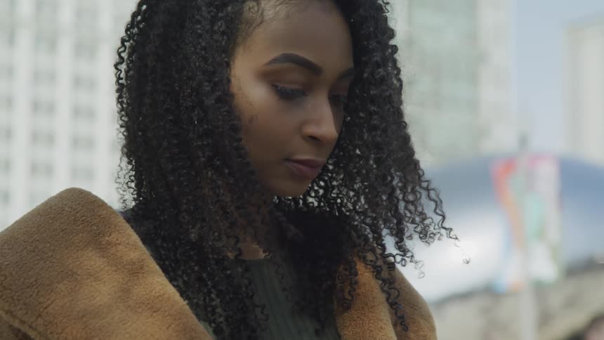 A young black woman standing outside