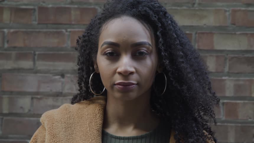 A young black woman standing outside