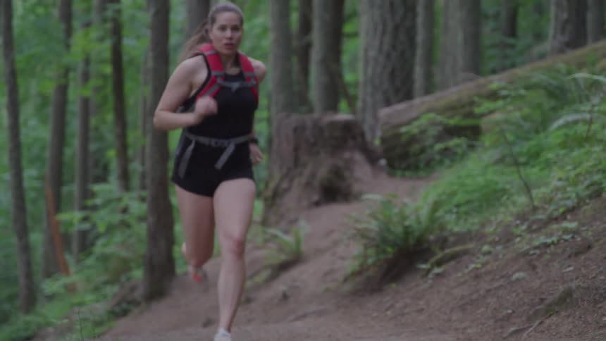 A teenage girl jogging through the forest