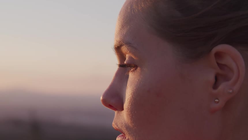 A woman is standing outside at dusk