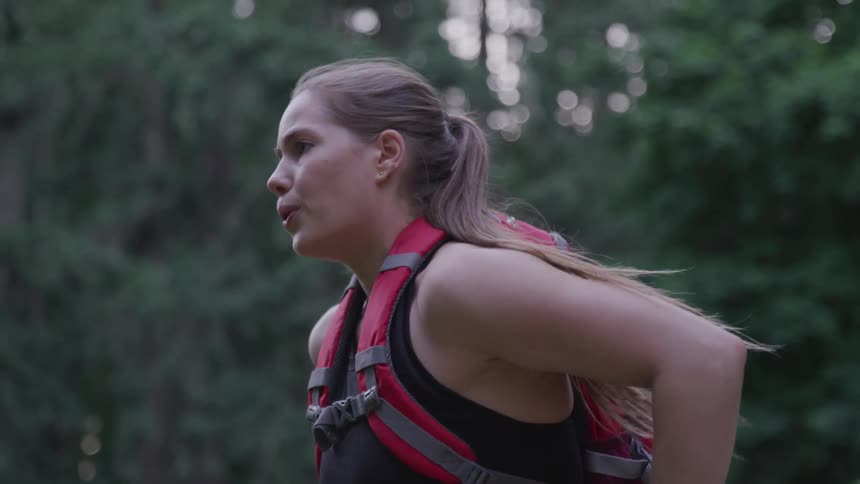 A woman is hiking through the forest