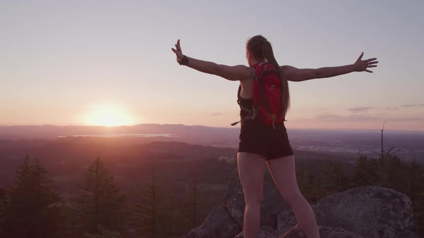 A woman is hiking outdoors at dusk