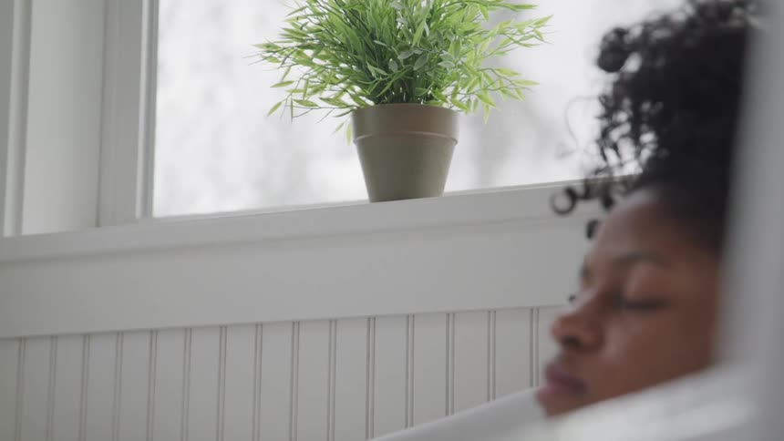 A woman closes her eyes as she lies in a bathtub