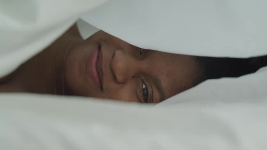 Woman smiles as white sheet falls over her