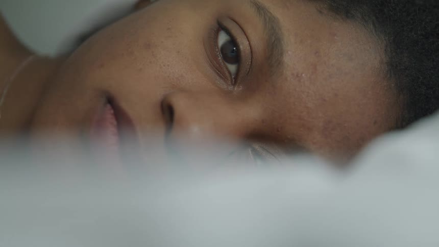White sheet covers face of woman laying down