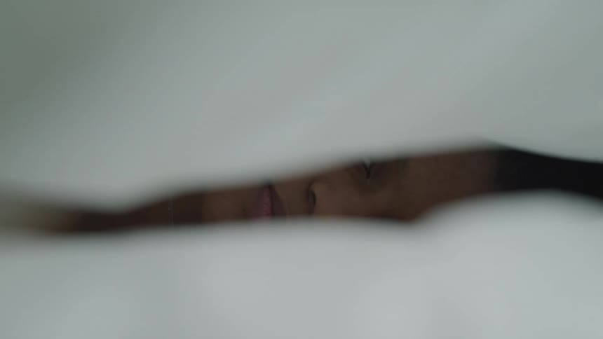 A black female lying in bed