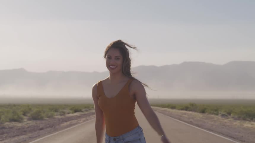 A woman is walking on an empty road