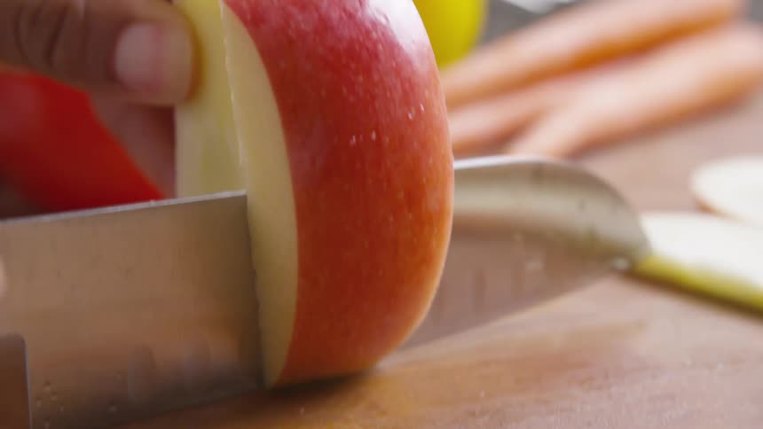 A person is cutting an apple with a knife