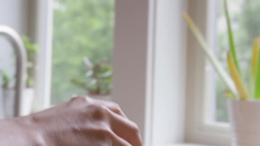 A person pulls an apple from a paper bag and places it on a cutting board