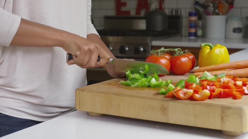 A woman chopping vegetables at home