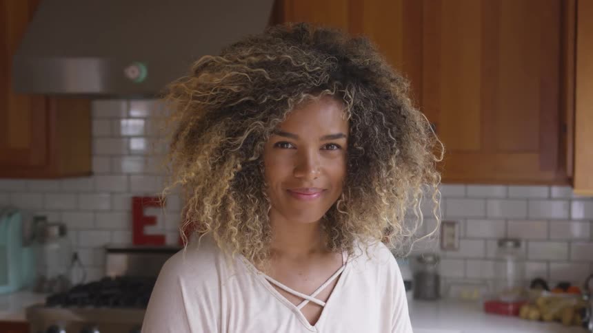 A woman standing in a kitchen smiling