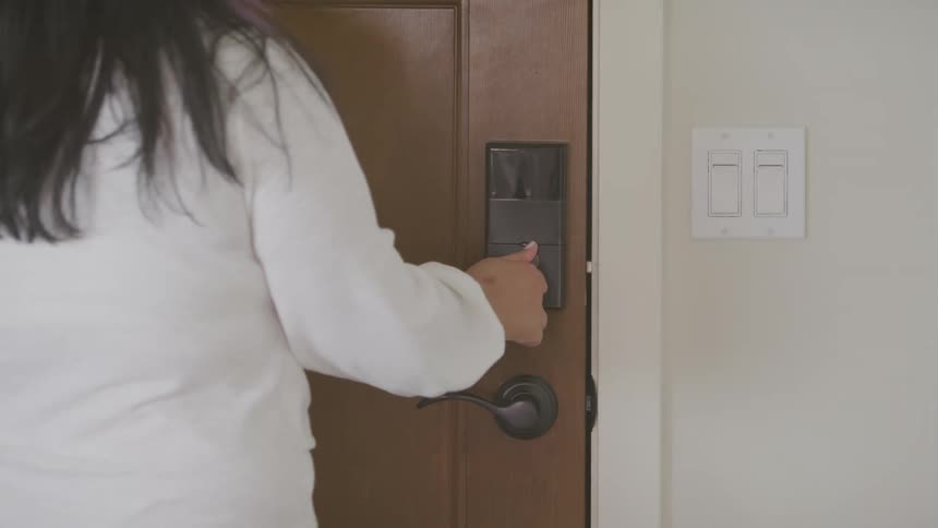 A woman locks a door inside her home