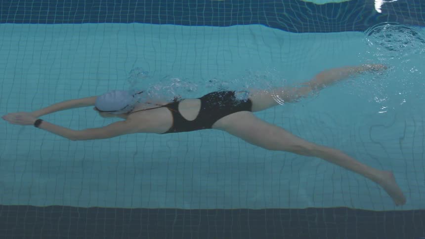 Woman doing breaststroke swimming in pool