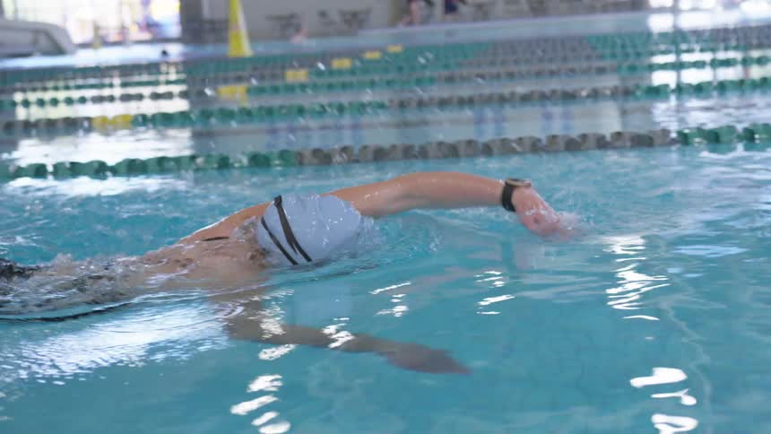 A teenage girl swimming laps in a pool