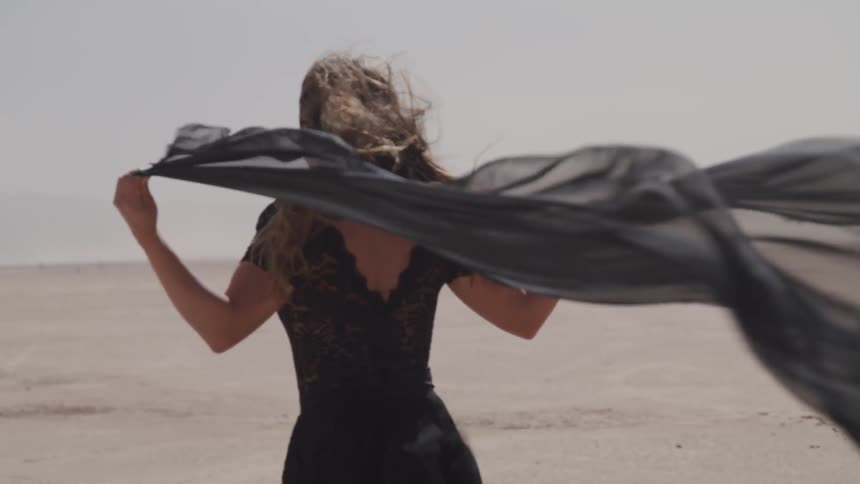 A woman is standing in a desert