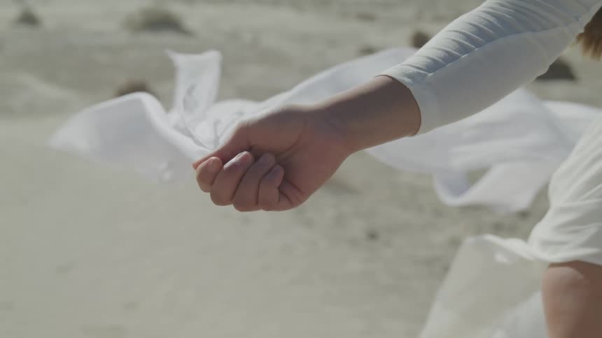 Woman holds skirt as wind blows it upward showing her leg