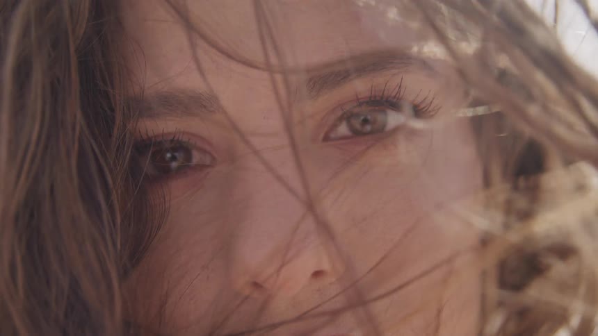Close up of a teenage girls face as the wind blows her hair around