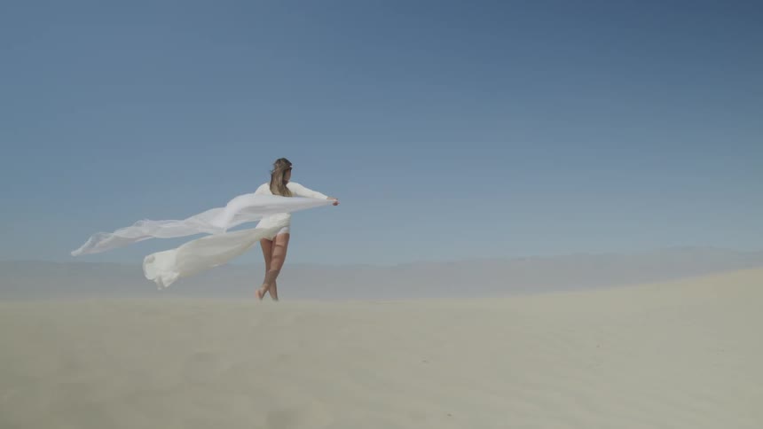 A woman is walking on the sand