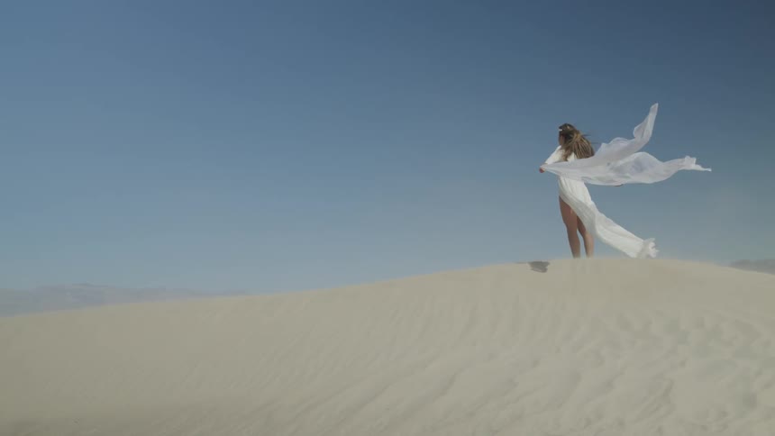 A woman is standing in the desert