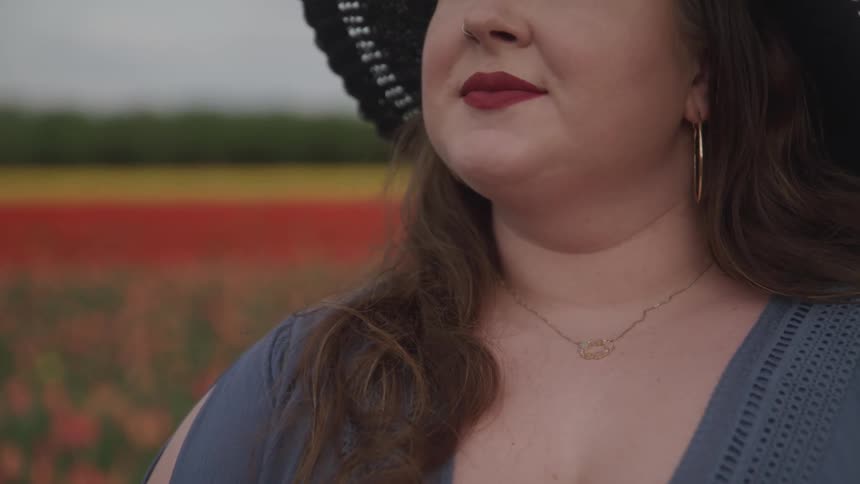 A woman is standing in a field of flowers