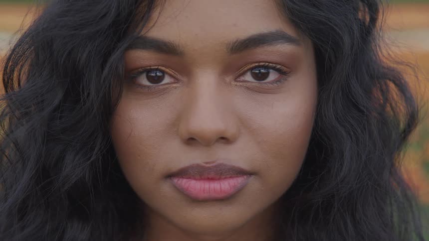 Young woman looks into camera with neutral expression