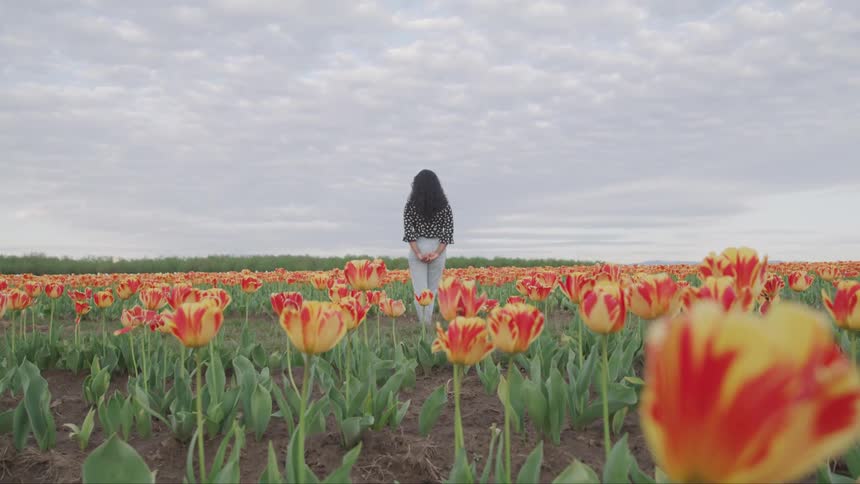 A woman standing in a field of flowers
