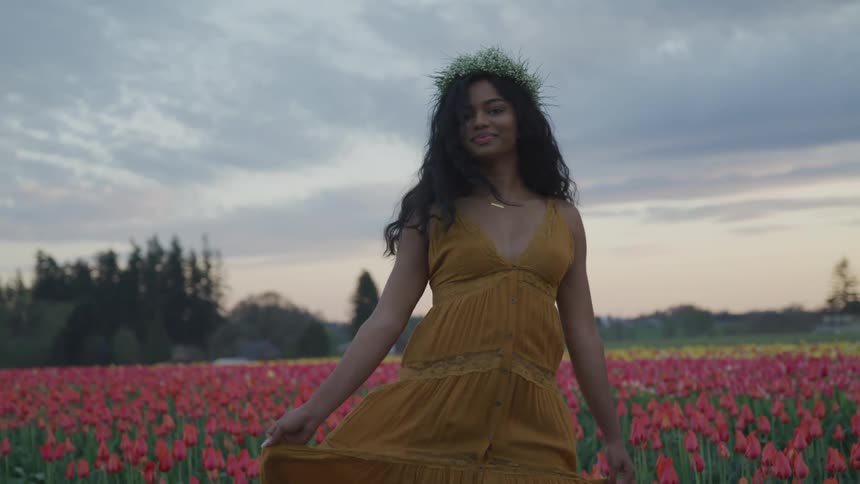 A woman is running through a field of flowers