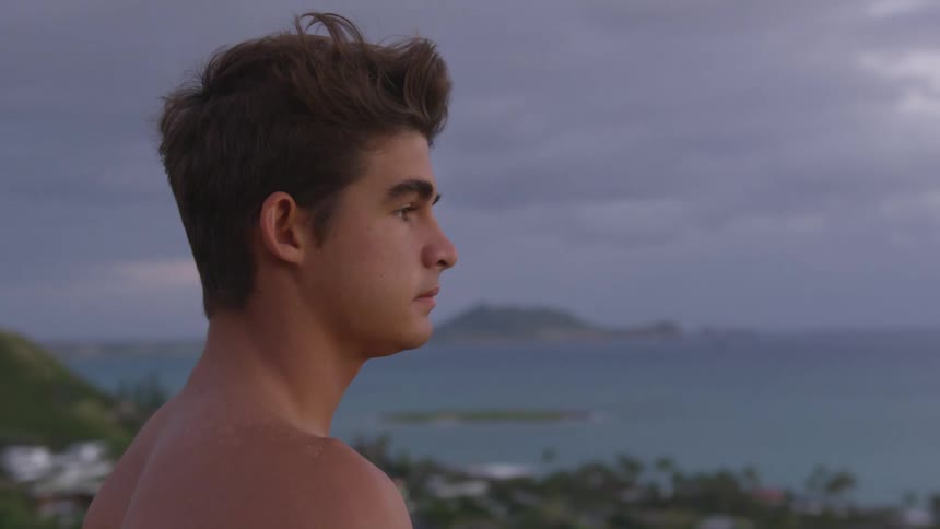 A teenage boy looks out at the water