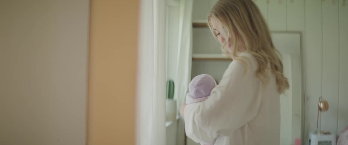 A woman rocking her baby in her arms at home