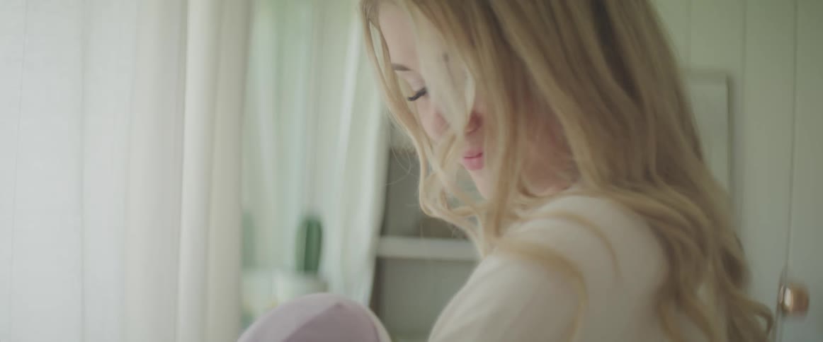 Young mother holds a baby in her hands in a room at home