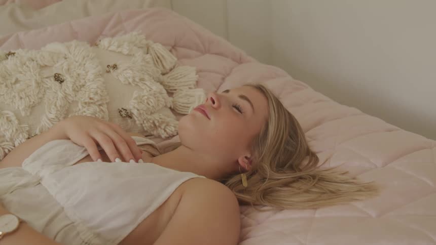 A teenage girl sleeping on a bed