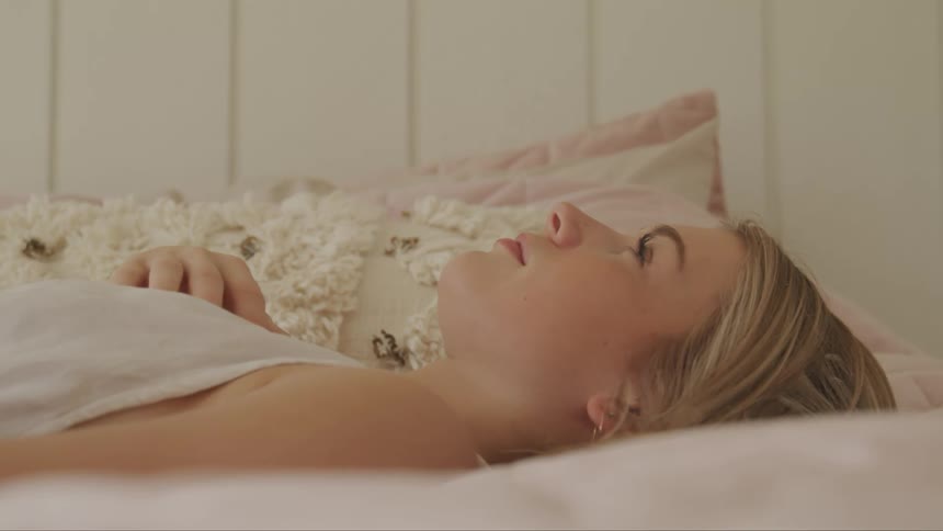 A woman is laying down on a bed