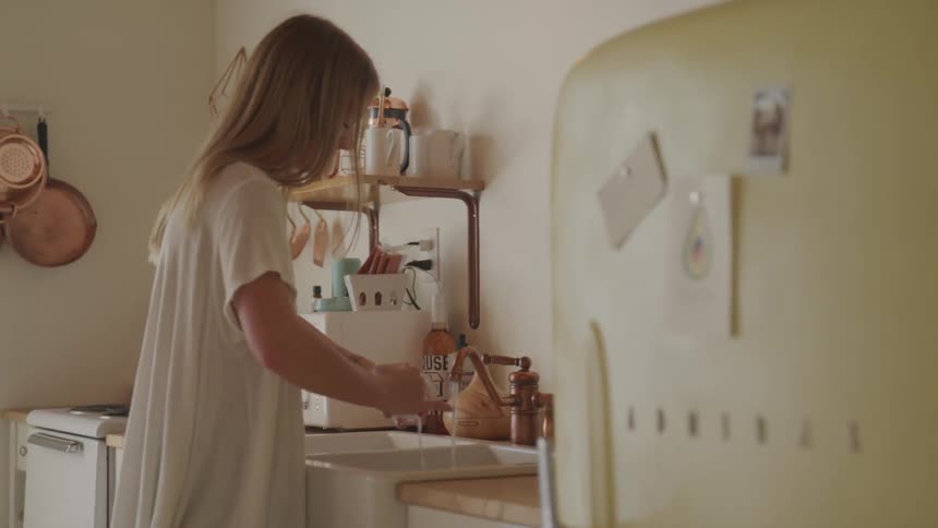 A woman washing dishes in her kitchen