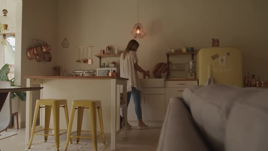 Woman in vintage styled home kitchen mixing in copper bowl