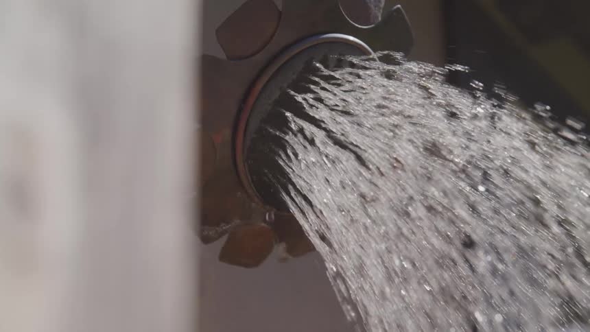 Metal shower head spraying water