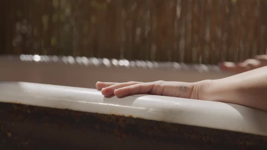 Woman lies in an old bathtub