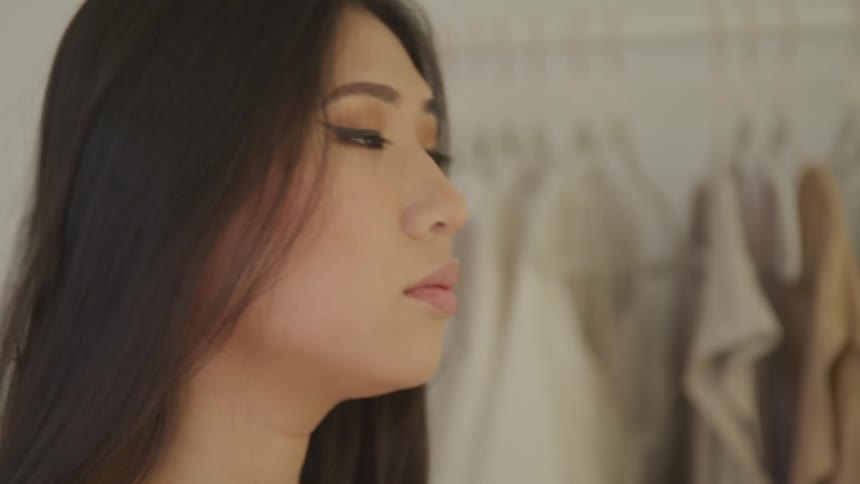A woman pushes her hair back with her hands as she checks her makeup