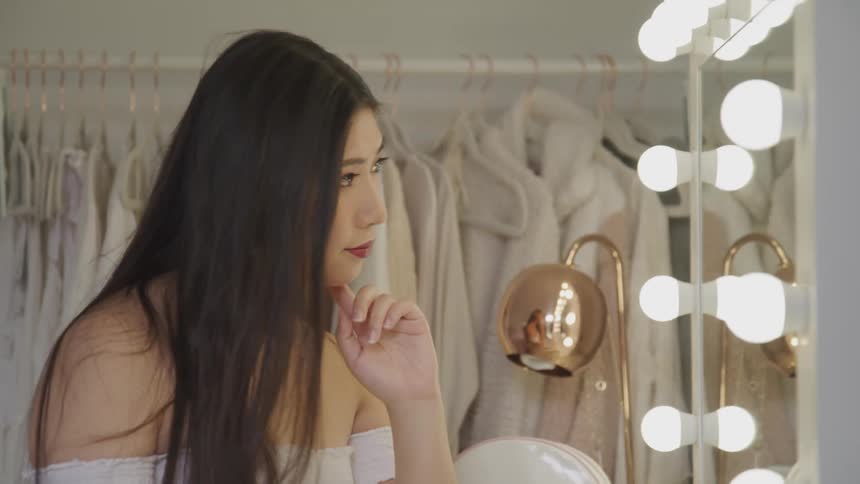 A woman is looking at herself in the mirror