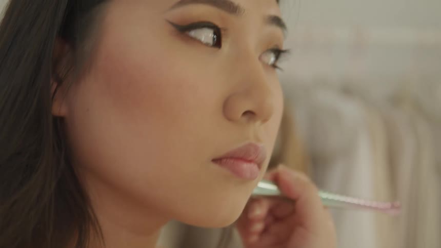 A teenage girl putting make up on