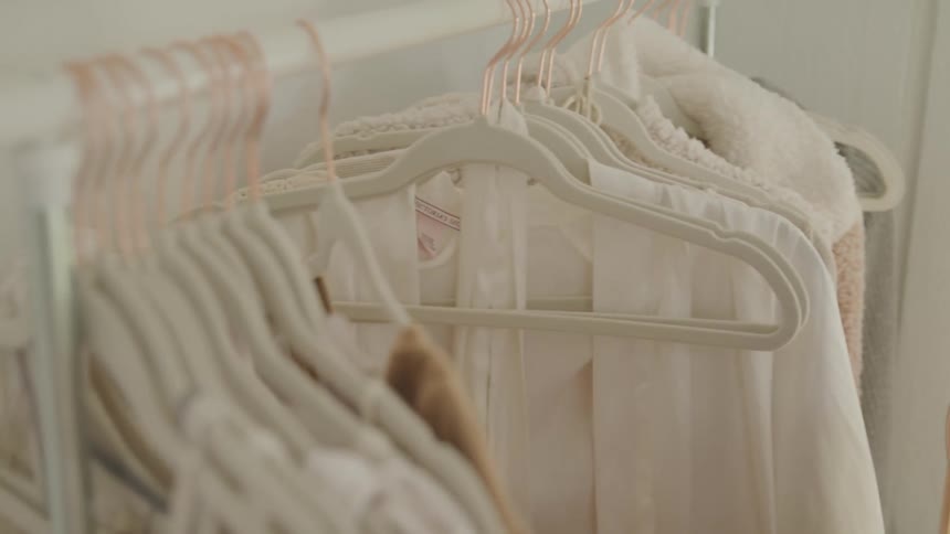 A young asian woman looks through clothing on a clothing rack